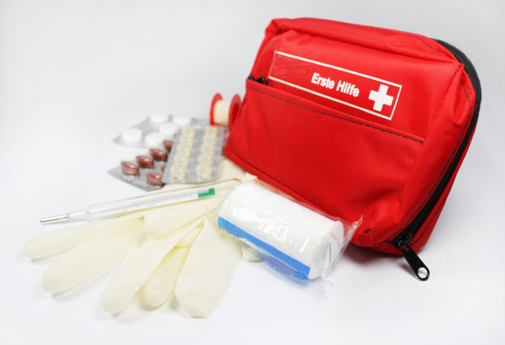 Reiseapotheke mit Tasche, Tabletten und Verband.